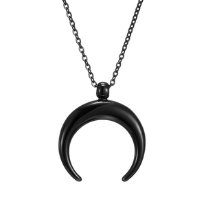 Detail of a minimalist black crescent moon pendant on a delicate stainless steel chain