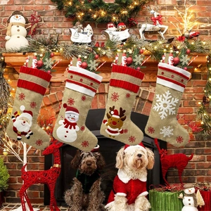 Cozy fireplace scene with four burlap Christmas stockings featuring Santa and reindeer embroidery