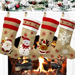 Set of 4 linen Christmas stockings with Santa and reindeer hanging on a festive fireplace