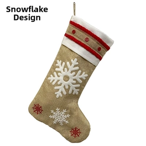 Macro shot of burlap Christmas stocking with white snowflake prints and red button accents