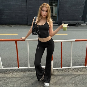 Close-up of black halter crop top and low-waist flared pants set in high-stretch fabric