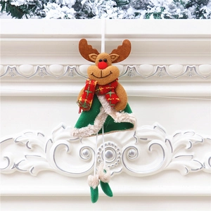 Christmas reindeer felt ornament with red scarf and green cloak hanging on pine branch