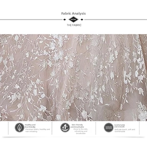 Detail van ademend wit bloemenkant op roze mesh stof voor luxe avondjurken