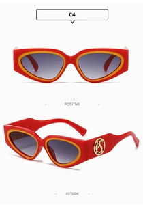 Macro view of red cat eye sunglasses with yellow trim and golden metal logo details