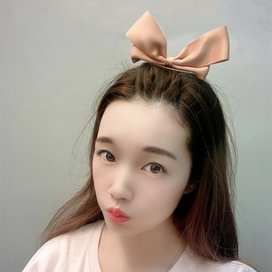 Detail of a pink satin ribbon bow hair clip with cute rabbit ears worn by a woman