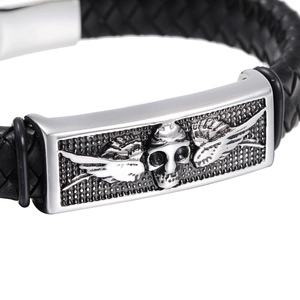 Men's braided leather bracelet with silver skull wing metal plaque on white background