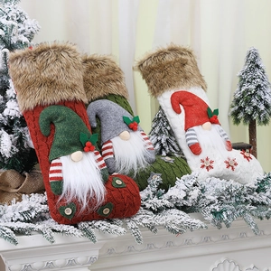 Three knitted Christmas stockings with 3D forest gnomes on a snowy mantel display