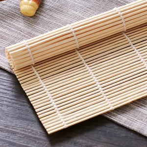 Bamboo sushi rolling mat shown in open and rolled positions on a wooden surface