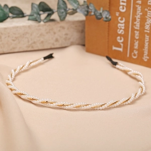 Detail of twisted white pearls and gold wire headband with elegant spiral texture