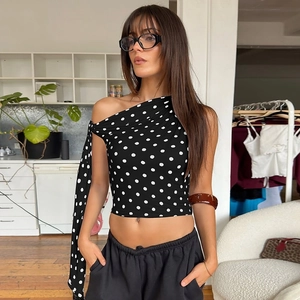 Detail of polka dot one-shoulder crop top with elegant sash tie and slim fit design