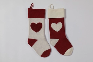 Close-up of knitted Christmas stockings with 3D heart patterns and hanging loops