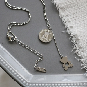 Detail of silver bear heart necklace with engraved round tag and 18KGP metal hallmark