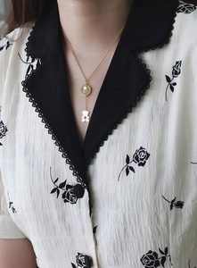 Detail view of rose gold bear pendant necklace with white shell inlay on model