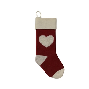 Detail view of red knitted Christmas stocking with 3D white heart and loop hanger