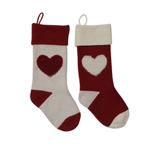 Detail of red and white knitted Christmas stockings with 3D heart pattern and hanging loops