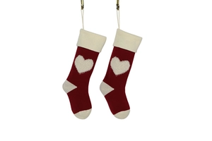 Close-up of red and beige knitted Christmas stockings with 3D heart pattern decoration
