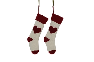 Detail of knitted Christmas stockings with 3D heart pattern in beige and deep red