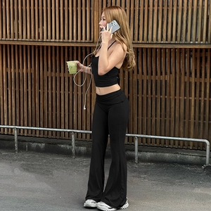 Detail of high-elasticity black halter crop top and flared high-waist trousers set
