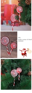 Detail of red and white spiral lollipop ornaments on a Christmas tree with festive lights