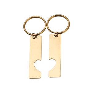 Close-up of golden puzzle heart keychains for couples in polished stainless steel