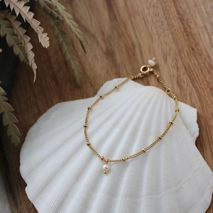 Mini freshwater pearl bracelet in 18K gold-plated titanium steel on a shell