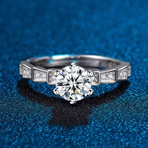 Macro detail of six-prong moissanite ring with geometric diamond-encrusted band