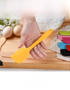 Colorful silicone spatulas with ergonomic handles in a professional kitchen setting