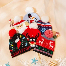Flat lay of colorful knit Christmas beanies with festive reindeer and snowman patterns