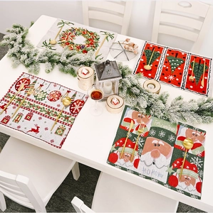 Close-up of knitted Christmas placemats with festive reindeer and Santa Claus patterns