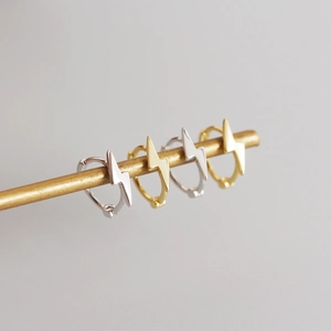 Detail of minimalist S925 silver lightning bolt hoop earrings in gold and silver finishes
