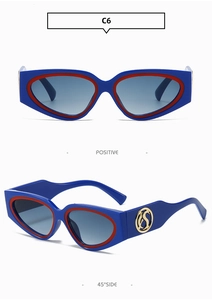 Detail view of cat eye sunglasses with blue frames, red edges, and golden logo accents
