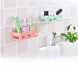 Detail of pink and green wall-mounted drainage baskets for bathroom and kitchen storage