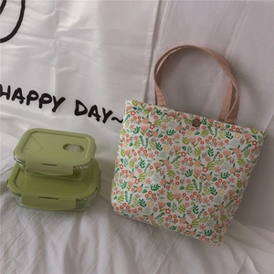 Detail of floral lunch bag showing metal snap closure and capacity with glass containers
