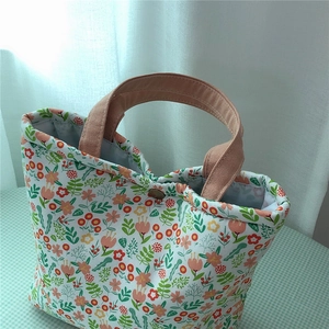 Detail of floral canvas tote bag with a wooden button closure and cotton webbing handles