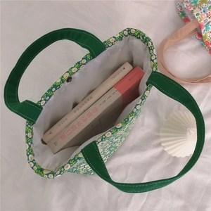 Detail view of floral canvas tote bag featuring magnetic buckle closure and inner space