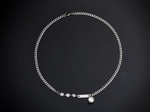 Close-up of silver Cuban chain necklace with sparkling crystals and a white pearl pendant
