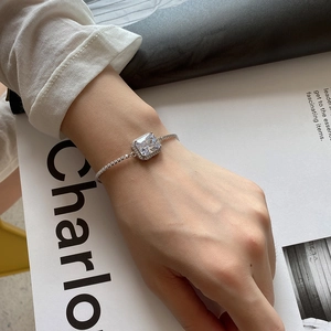 Detail of silver bracelet with emerald-cut cubic zirconia and pave-set chain on wrist