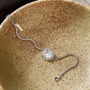 Close-up of a 925 sterling silver bracelet featuring a square zircon stone in a ceramic bowl