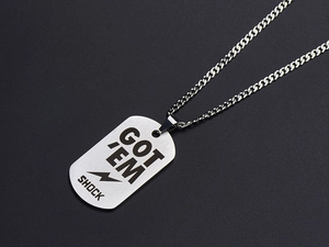 Detailed view of silver military tag pendant with GOT EM and SHOCK engraving on black