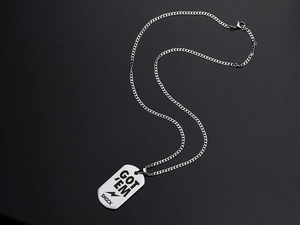 Macro view of Got 'Em Shock engraved rectangular military dog tag pendant on Cuban chain