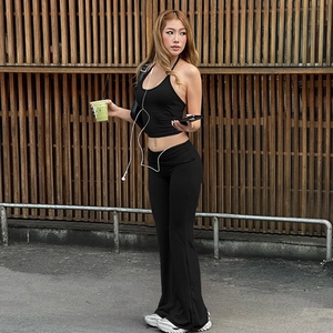 Detail view of black halter crop top and high-waisted flared pants with waist fold