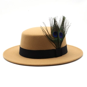 Detailed view of camel wool felt hat with black band and natural peacock feathers