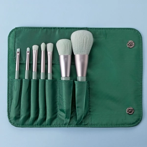 Detailed set of 7 mini makeup brushes with green handles in a portable matching pouch