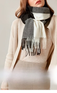 Close-up of black and white plaid cashmere-like scarf with long fringe detail