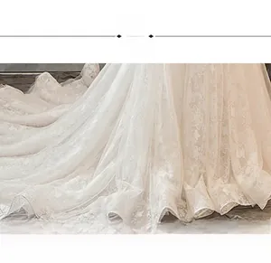 Detailed macro shot of white wedding dress fabric with intricate 3D floral lace embroidery