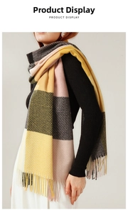 Close-up of yellow, pink, and grey plaid scarf with long fringe details in soft texture