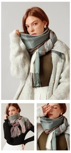 Close-up of thick plaid winter scarf with fringe details in neutral color tones