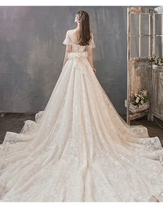 Exquisite back view of bridal gown featuring a long train and large lace bow detail