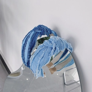 Vue détaillée de serre-têtes en jean avec nœud réfléchis sur un miroir en forme de cœur