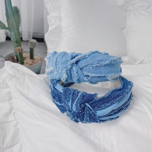 Détails de bandeaux en denim effiloché bleu clair et foncé sur une surface en tissu blanc